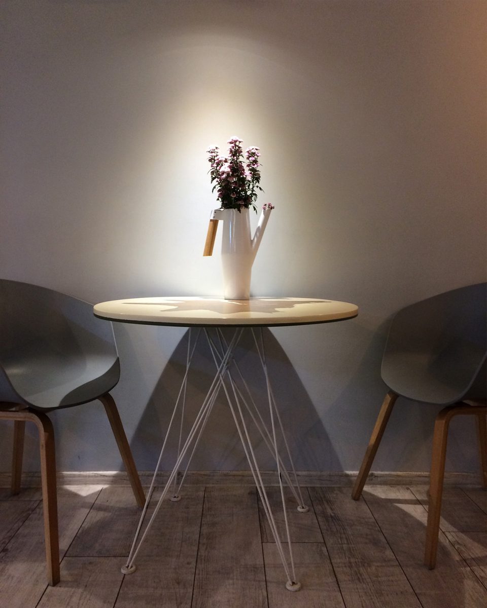 kleiner runder Tisch mit Blumenvase und Licht